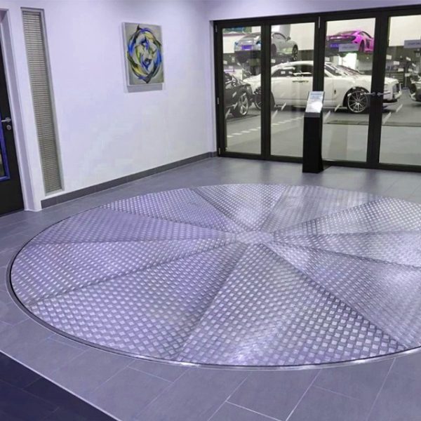 Car Turntable Platform with Pin-Gear Drive Effortlessly solve driveway challenges and limited parking access with our advanced car turntable platform. Designed for both indoor and outdoor use, this rotating platform offers smooth, reliable, and low-maintenance operation, ensuring convenience and enhanced functionality. Innovative Design and Construction Our car turntables are built with durability and precision in mind. The turntable’s pin-gear drive mechanism ensures smooth operation with minimal wear and tear, outclassing traditional friction drive systems that are prone to noise and higher maintenance. Pin Tooth Plate: Crafted from 10mm thick steel, precision-cut using CNC machinery, and treated for maximum durability. Nylon Components: High-strength nylon gears and wheels deliver superior abrasion and corrosion resistance while significantly reducing operational noise. Adjustable Height: Equipped with four supporting bolts and a central seat with adjustable shaft sleeves, the turntable can accommodate uneven installation surfaces. Seamless Functionality and Efficiency The car turntable offers unparalleled rotational capabilities, making it an ideal solution for tight parking spaces and restricted driveway access. Rotation and Capacity: Capable of 360° continuous rotation at variable speeds (0.2–1 RPM), the turntable can support weights ranging from 3,000 to 8,000 kg, making it suitable for a wide range of vehicles. Mesa Options: Choose from multiple diameter sizes (4m to 9m) and materials, including density board, plywood, and pattern aluminum alloy, to match your specific requirements. Advanced Control and Safety Features Our platform is designed with user convenience and safety in mind. Control Options: Operate the turntable using manual control, remote control, or angle-specific rotation control, ensuring precision and ease of use. Reliable Motor and Drive: The AC frequency conversion brake motor ensures smooth engagement of the main gear and stable rotation. Key Advantages Over Competitors Our car turntable stands out with its innovative design and cutting-edge features: Pin-Gear Drive Mechanism: Provides superior reliability, lower maintenance, and quieter operation compared to friction-drive systems. Noise Reduction: High-strength nylon gears and wheels significantly reduce noise levels during operation. Customizable Options: Choose from various sizes, materials, and control modes to meet your unique needs. Versatile Applications Whether you need a turntable for a residential driveway, a commercial garage, or an industrial parking lot, this platform offers unmatched versatility and performance. Upgrade your parking experience with our Car Turntable Platform with Pin-Gear Drive—a reliable and innovative solution for modern parking challenges.